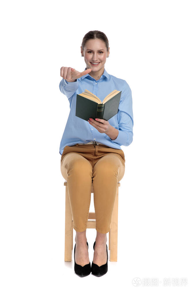 一个拿着书指着手指的年轻女人