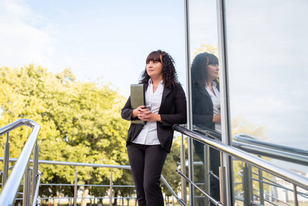 城市女商人带着橘子夹走路的商人与文件夹走半快乐女商人与文件夹走
