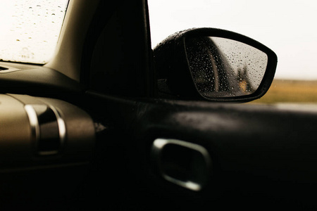 下雨车窗透过玻璃看到后视镜.车窗湿了.关闭雨滴.汽车视图见镜子.照片