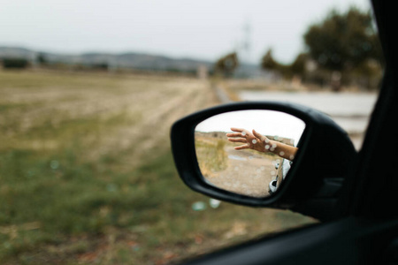 手触雨滴.透过玻璃看到的镜子.车窗湿了.关闭雨滴.汽车视图见镜子.