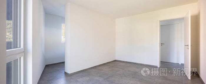 Empty room with white walls, open door and access to the rooms 