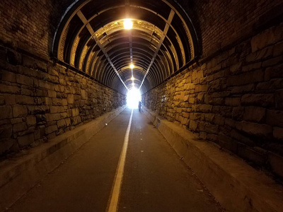 带石墙和隧道末端照明的隧道图片