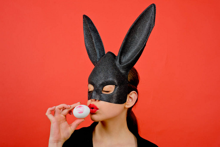 粉红底兔子面具女人.女性嘴吻.唇膏吻印.红底复活节彩蛋上的红唇印.