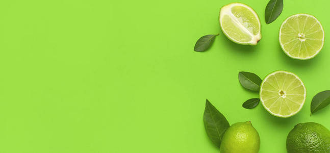 新鲜多汁的青柠和绿叶,背景为鲜绿色.俯视图平面复制空间.