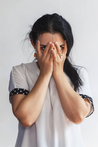 美丽而年轻的女士掩面用手看着.