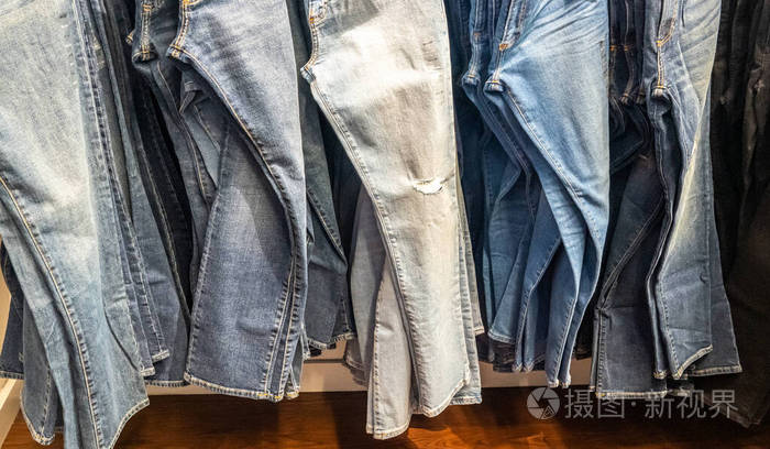 挂在架子上的牛仔裤一排牛仔裤买卖买买的概念和牛仔裤时尚