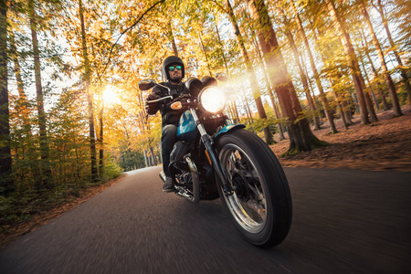摩托车司机在森林景观中骑行照片