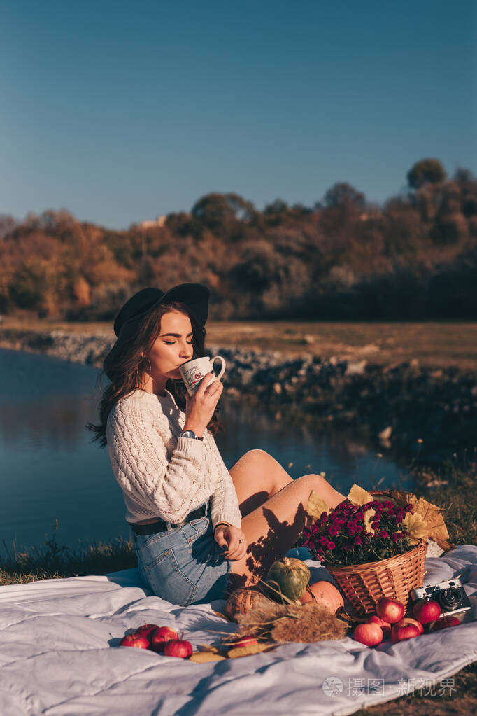 坐在湖边喝茶的自然妇女肖像