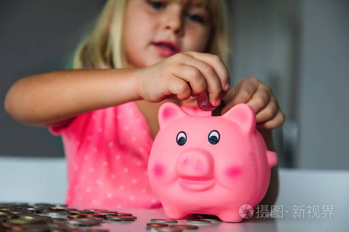孩子存钱可爱的女孩把硬币放进储蓄罐