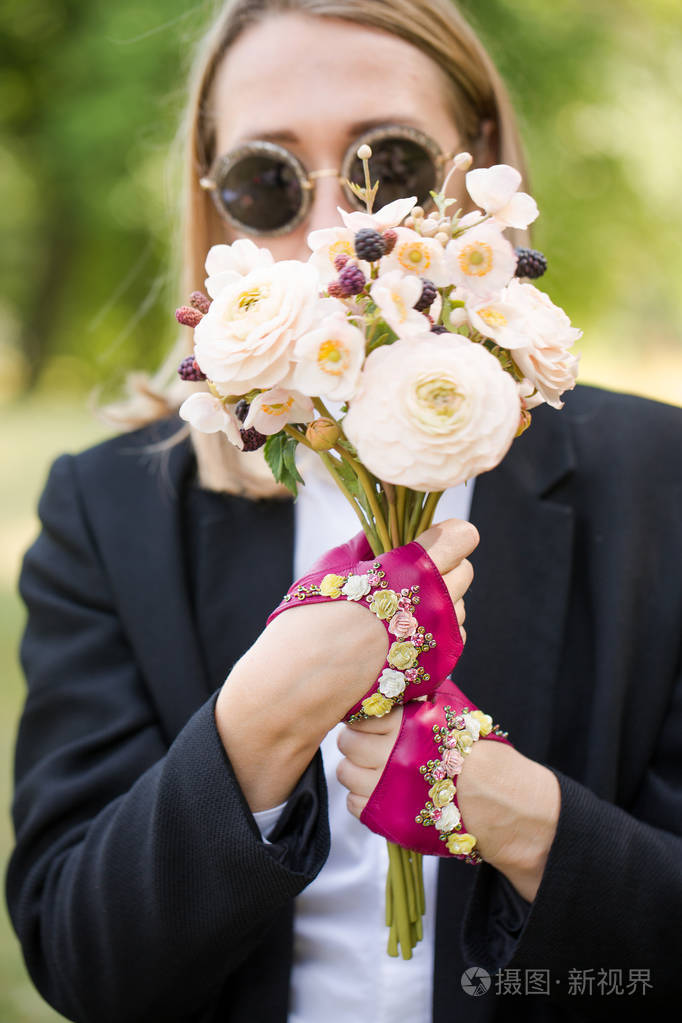 戴着粉红色短手套的女孩拿着一束花