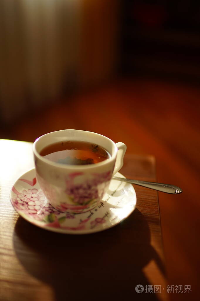 在阳光明媚的桌子上一杯优雅的红茶