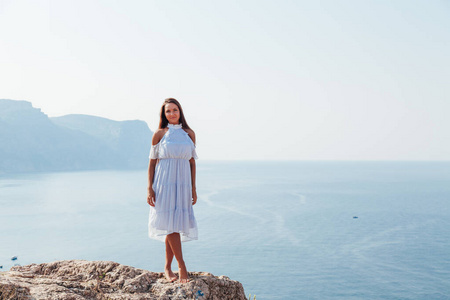 一位长发美女在俯瞰大海的山上的画像照片