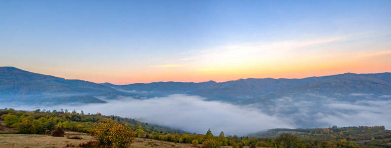 雾中的群山中的城市全景图片