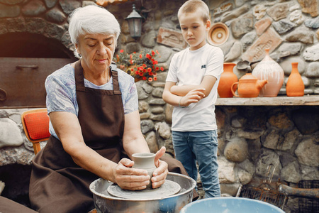 祖母和孙子孙女用陶器做水罐图片