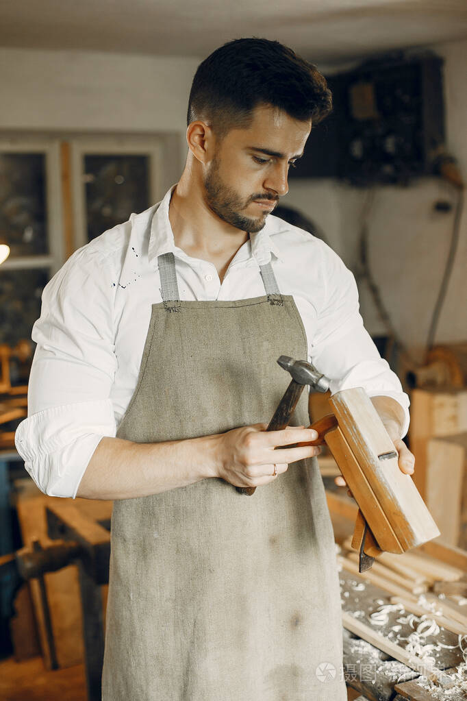 英俊的木匠在用木头干活