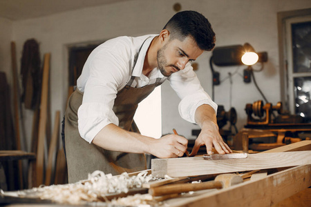 英俊的木匠在用木头干活照片