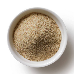 细碎的白胡椒粉放在白色陶瓷碗里照片