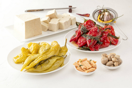 传统的韩国发酵食品-红椒配香草,黄咸辣椒和豆腐豆腐放在白桌子上照片