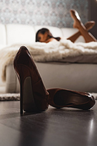 女卧室前的高跟鞋散焦了.性感的女人在床上放松.迷人的女性放松.按摩.