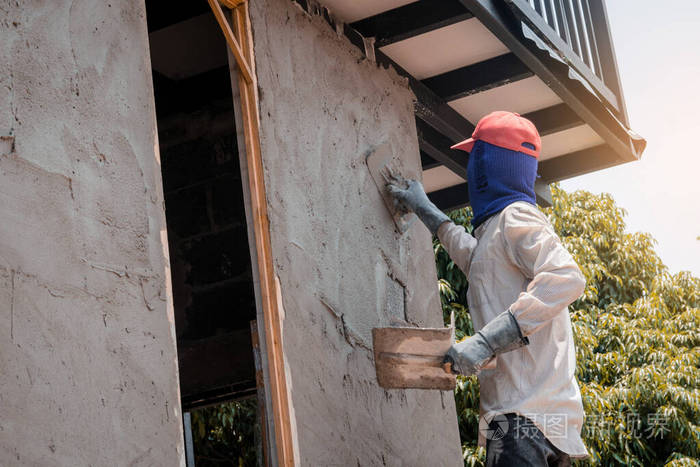 建筑工人用水泥浆粉刷建筑墙面
