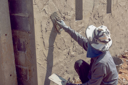 建筑墙面建筑工人用水泥浆粉刷建筑墙面油漆工在室内用伸缩辊粉刷墙壁