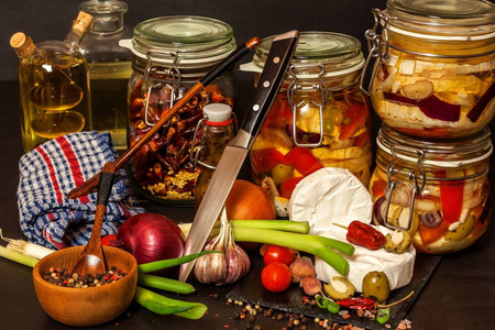 自制腌制奶酪.腌制食品.黑木桌上油浸卡门伯特奶酪罐.照片