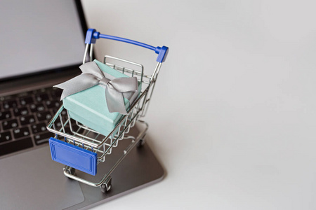 在白色背景下用笔记本电脑和购物车进行网上购物的创意促销组合.