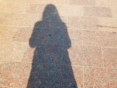 一个人在大理石板上的影子.人行道上的人的影子照片