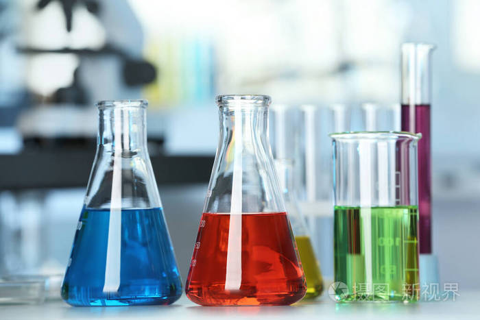 实验室桌上摆着五颜六色液体的玻璃器皿