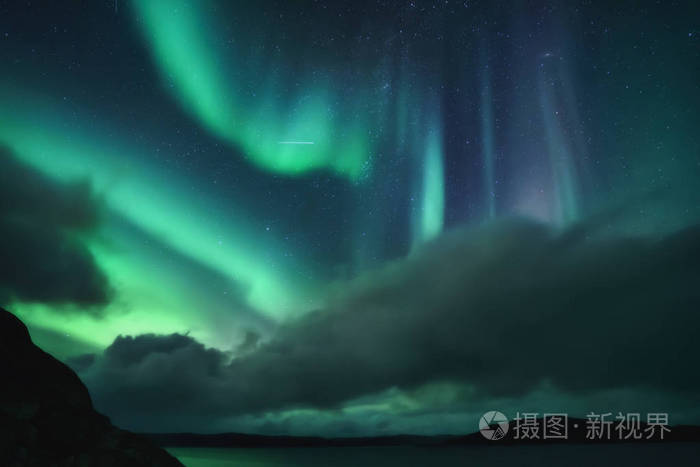 北极光，北极光在科拉半岛夜空中照亮了绿色。俄罗斯摩尔曼斯克地区