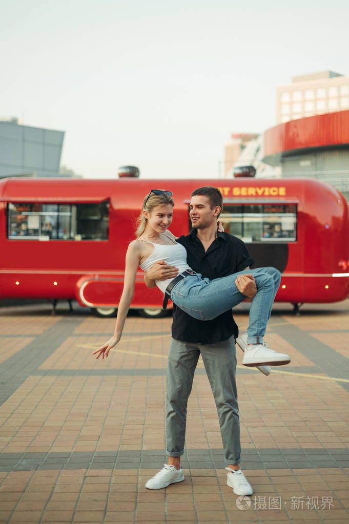 一对穿着时髦衣服的漂亮情侣背对着镜头摆姿势