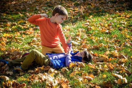 孩子摔跤两个男孩在户外打架.朋友们在夏季公园摔跤.
