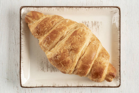 酥脆可口木桌上酥脆可口的羊角面包照片