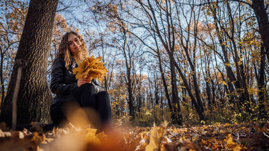 坐在春天树林里的木头上的女人.