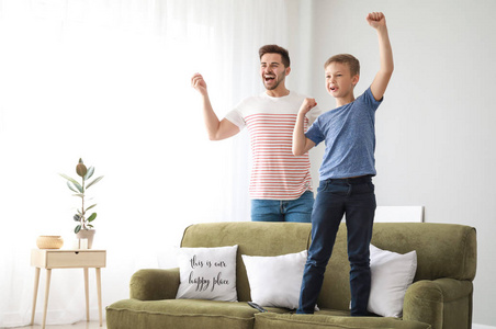 父亲和儿子在家看电视体育节目图片