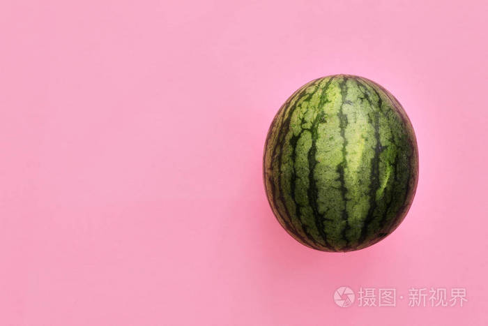 从上面看在珊瑚粉色的背景下孤立的西瓜