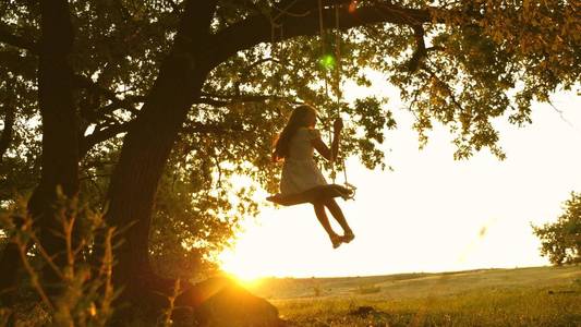 小女孩在大树上荡秋千图片