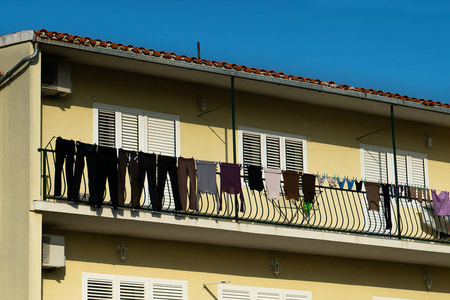 村舍阳台上晾着深色衣服和内衣图片