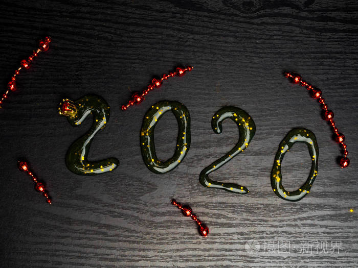 贺卡2020新年快乐。美丽的广角创意节日网页横幅或广告牌，带有金色亮片红色花环slime 2020字样的文字在木质背景上写下