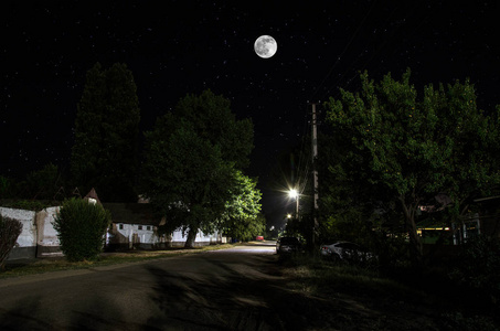 夜幕下,满月笼罩着宁静的村庄.古镇街夜景优美,灯火通明.俄罗斯照片