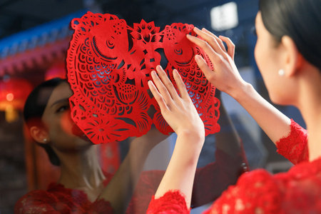 年轻女人过年贴窗花照片