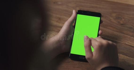 女性的青少年女孩使用智能手机和绿色的屏幕越过木材int.谢谢