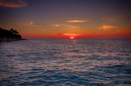 热带的日落向指已提到的人海滩,在近处罗维尼,克罗地亚