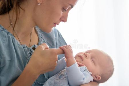 年幼的母亲,接吻的她新生的婴儿男孩在家