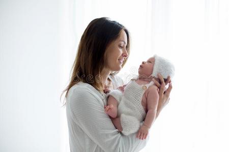 年幼的母亲,接吻的她新生的婴儿男孩在家,妈妈和婴儿