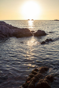 美丽的日落越过指已提到的人多岩石的海岸