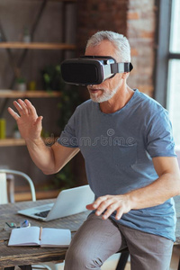 好奇的老年的男人测试VirtualReality虚拟现实眼镜在家