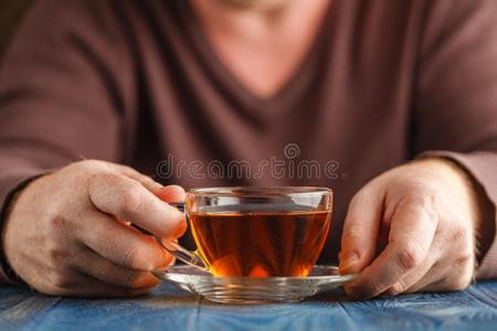 男性的拿住杯子关于热的茶水