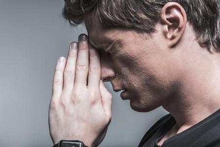 情绪低落的男人令人难于忍受的向集中的他的心向严肃的问题照片