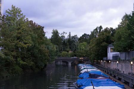 小的小船和雨盖采用运河和树和水反射